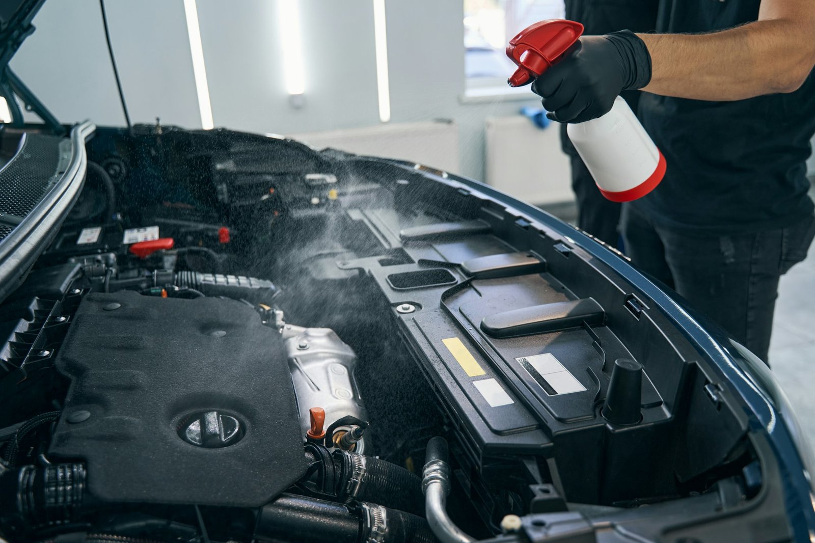 cleaning car engine with foam spray by serviceman dry auto washing